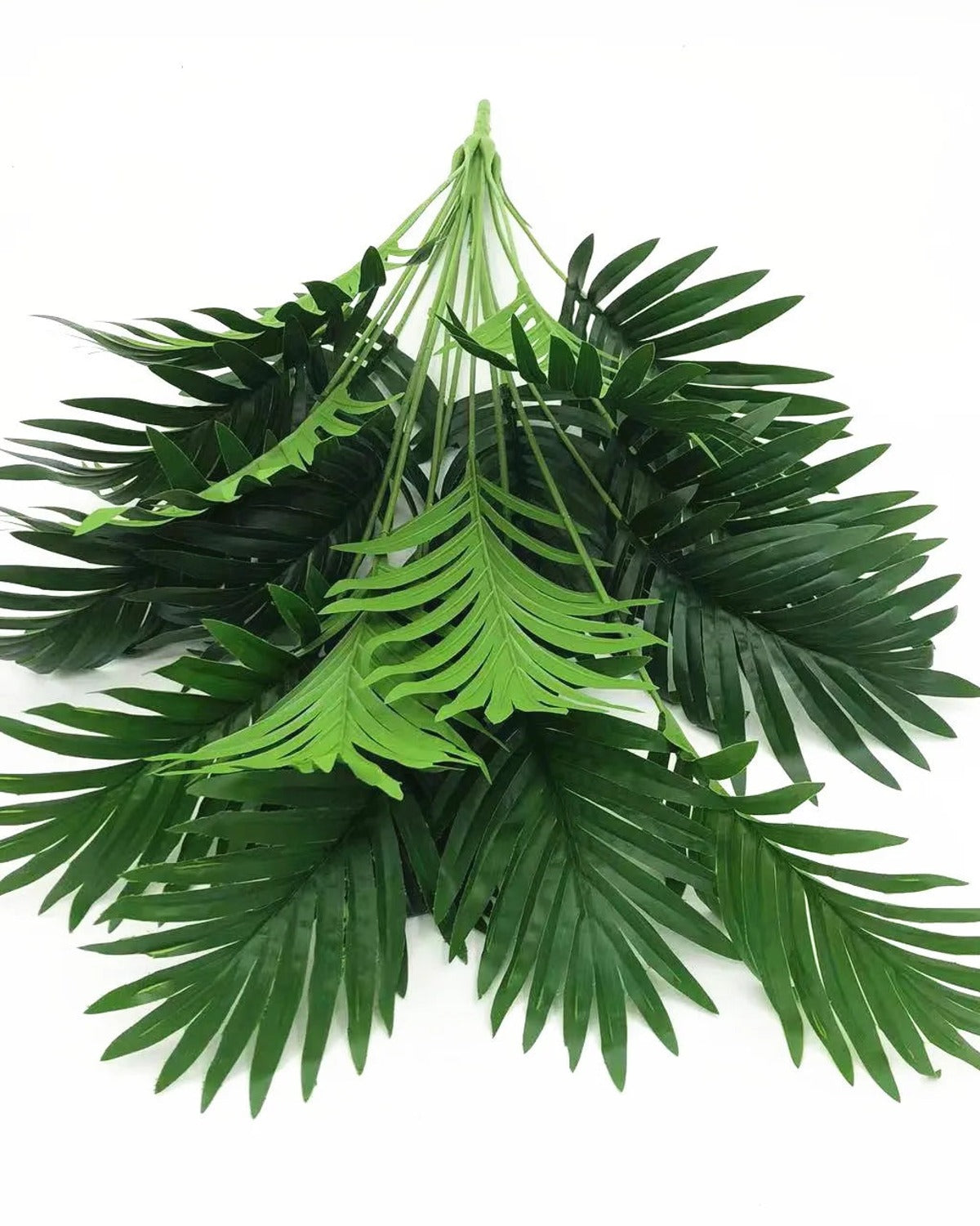 The artificial palm leaf bush laid flat on a plain background, showing all its fronds and the bound base