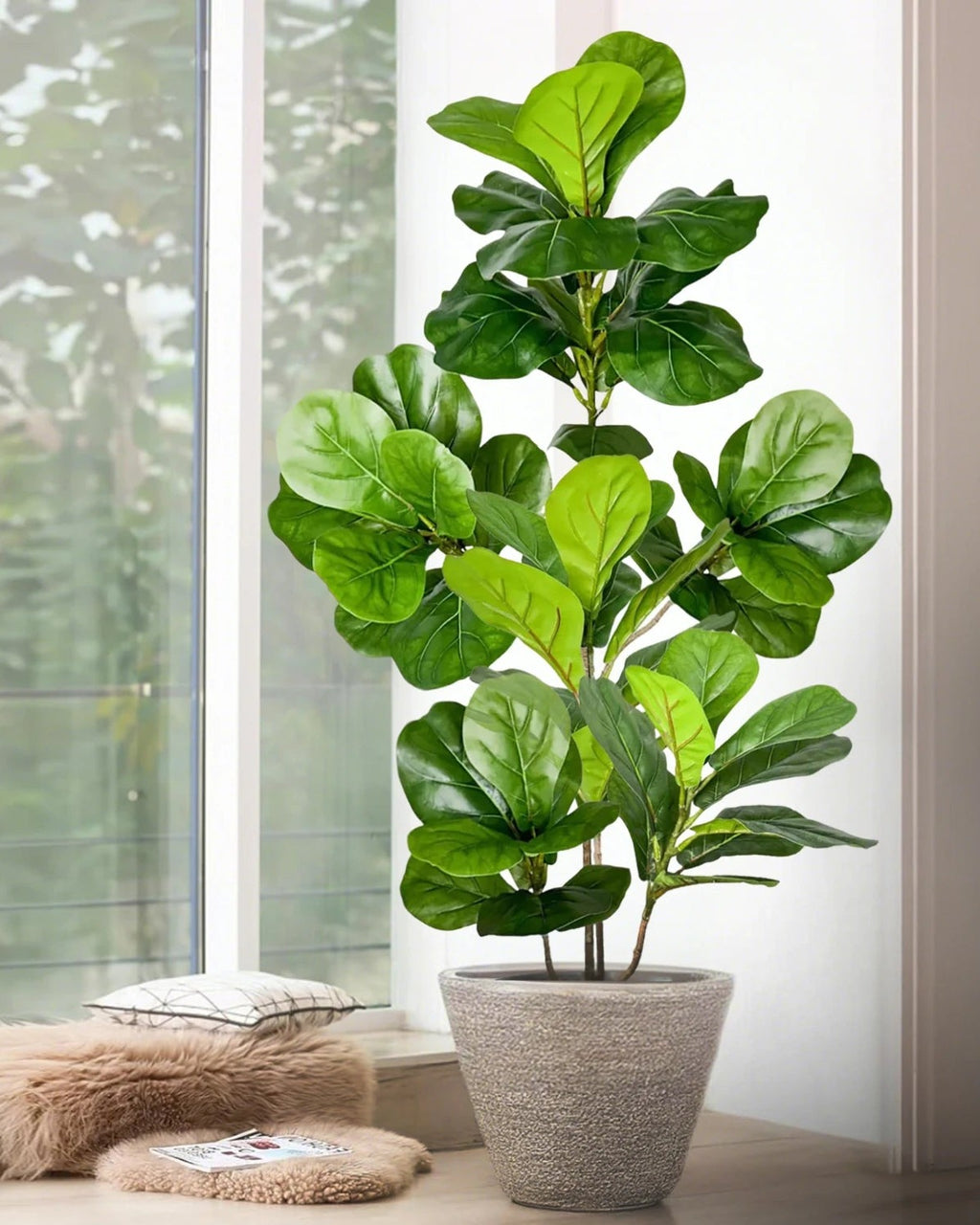 An artificial tree branch in a pot beside a window; pot not included