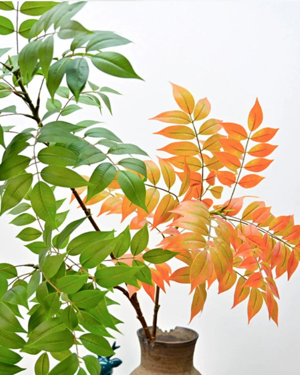 The autumn form of the artificial tree branch beside the green, showing the color difference; pot not included