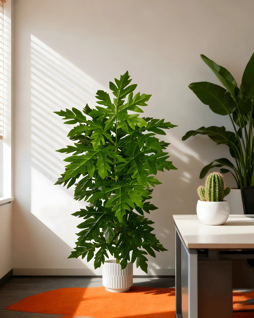 An artificial papaya leaf plant in a sunlit corner beside a window; the other plants in the room are not part of the order, and no pot is included