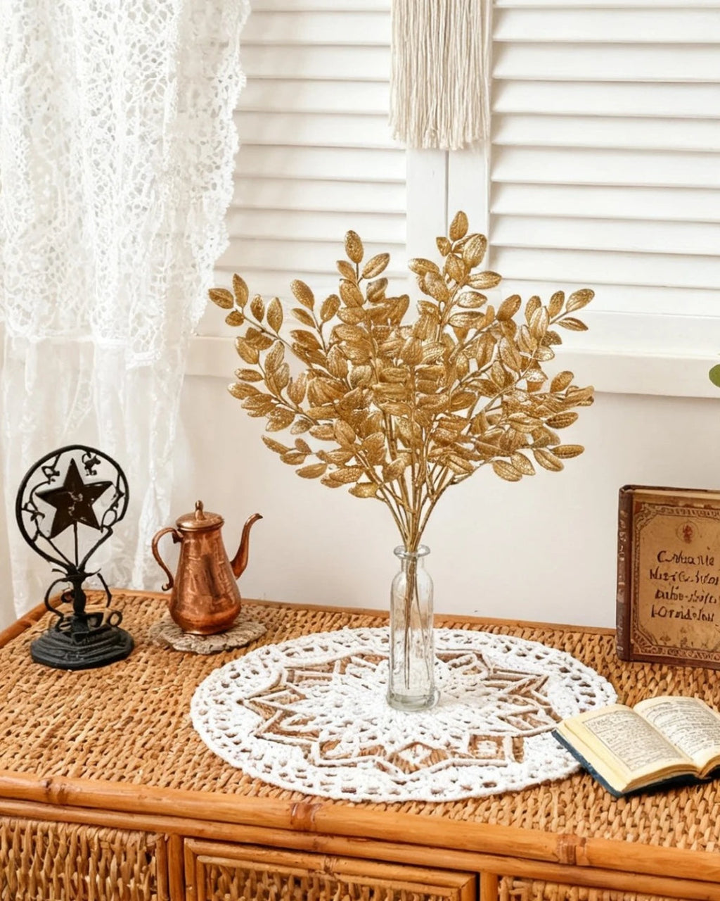 Artificial gold leaf stems in a glass vase on a dresser; no vase is included