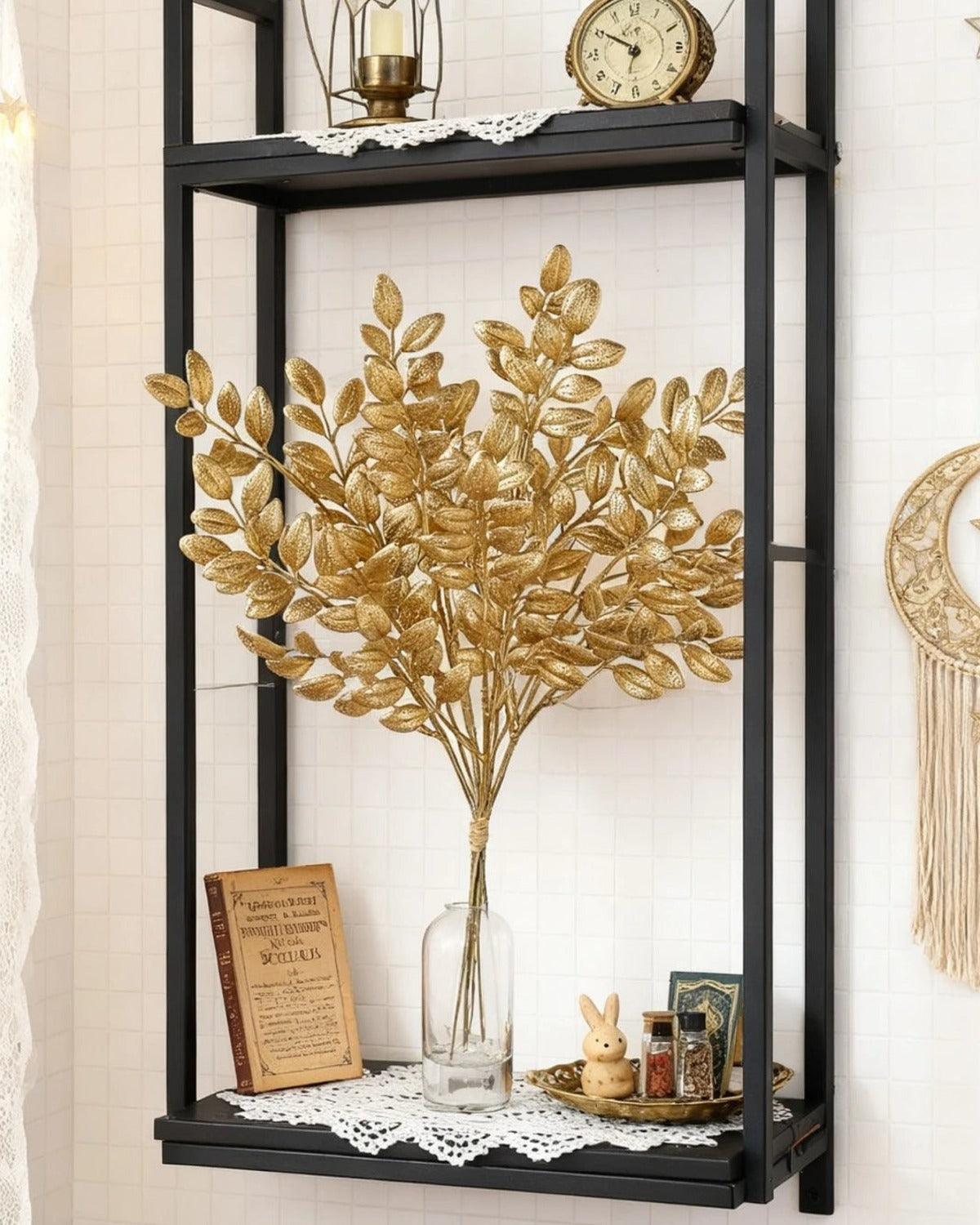 Artificial gold leaf stems in a vase on a shelving unit; no vase is included