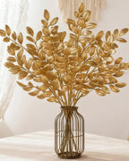 Artificial gold leaf stems in a wire and glass vase; no vase is included