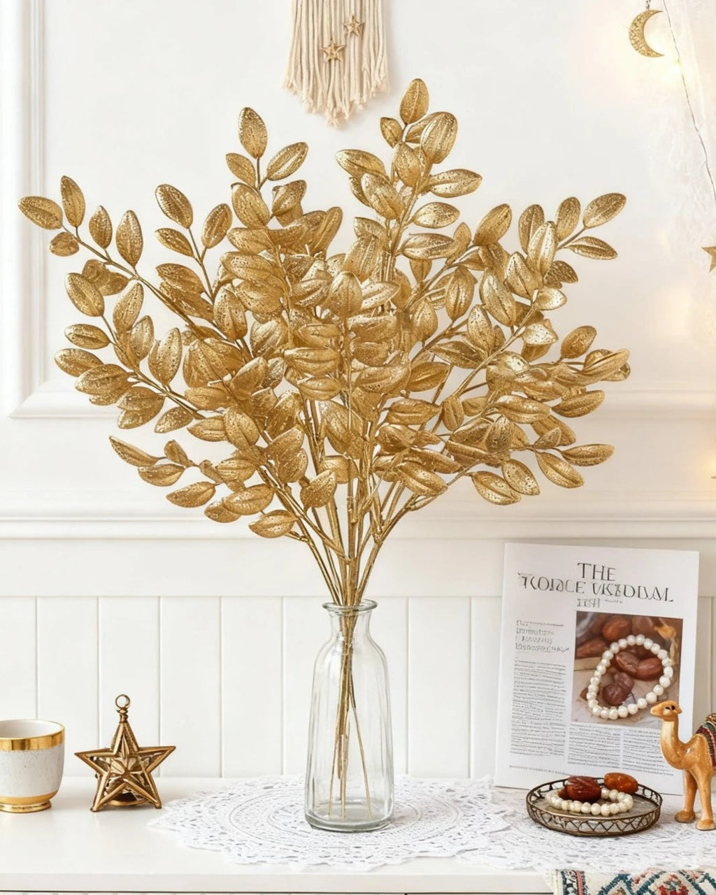 Artificial gold leaf stems in a glass bottle vase; no vase is included