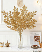 Artificial gold leaf stems in a glass bottle vase; no vase is included