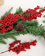 Artificial berry branches laid with pine foliage and a pine cone; only the berry branches are part of the order