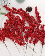 Artificial berry branches laid out on a white cloth with a pine cone; only the berry branches are part of the order