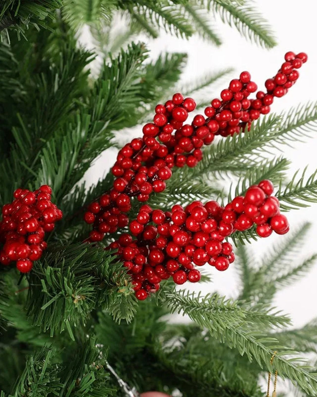 Artificial berry branches tucked into a Christmas tree; only the berry branches are part of the order