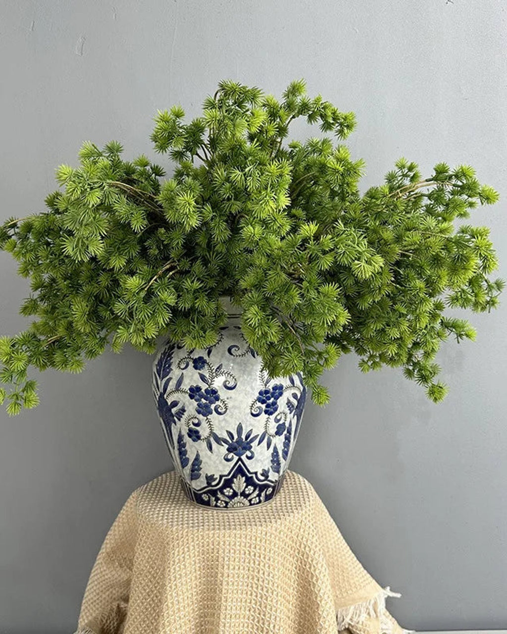 Several artificial pine branches arranged in a patterned jar; each order is one branch, and no vase is included
