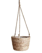 A woven hanging plant basket on its jute ropes, empty