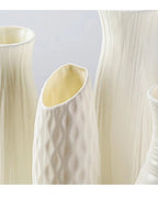 Four of the white origami vase shapes side by side, empty