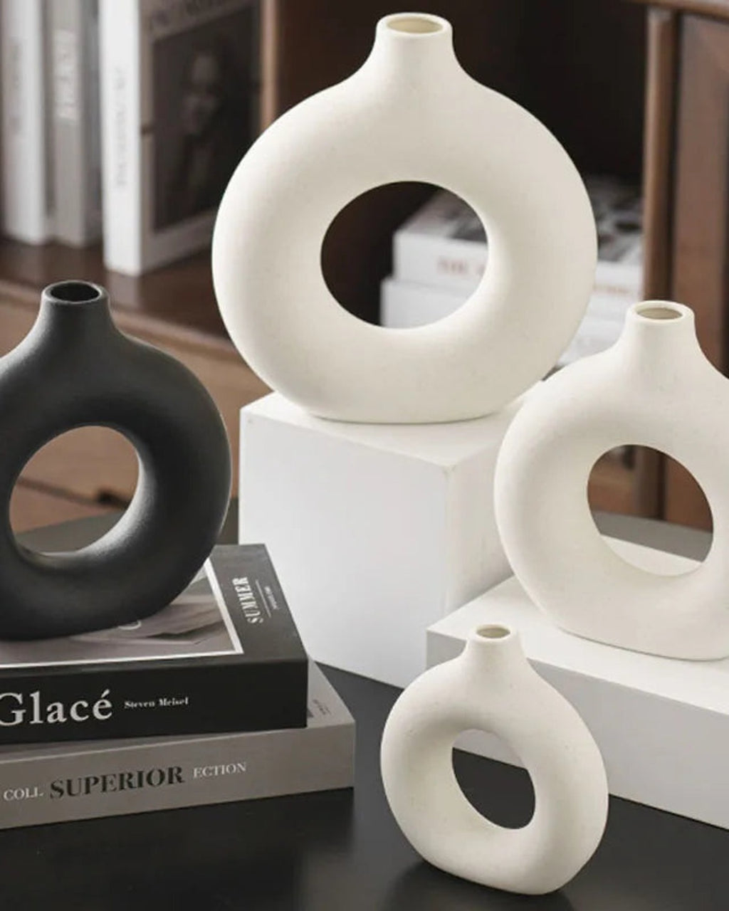 Black and white donut vases stacked on books; books and flowers not included