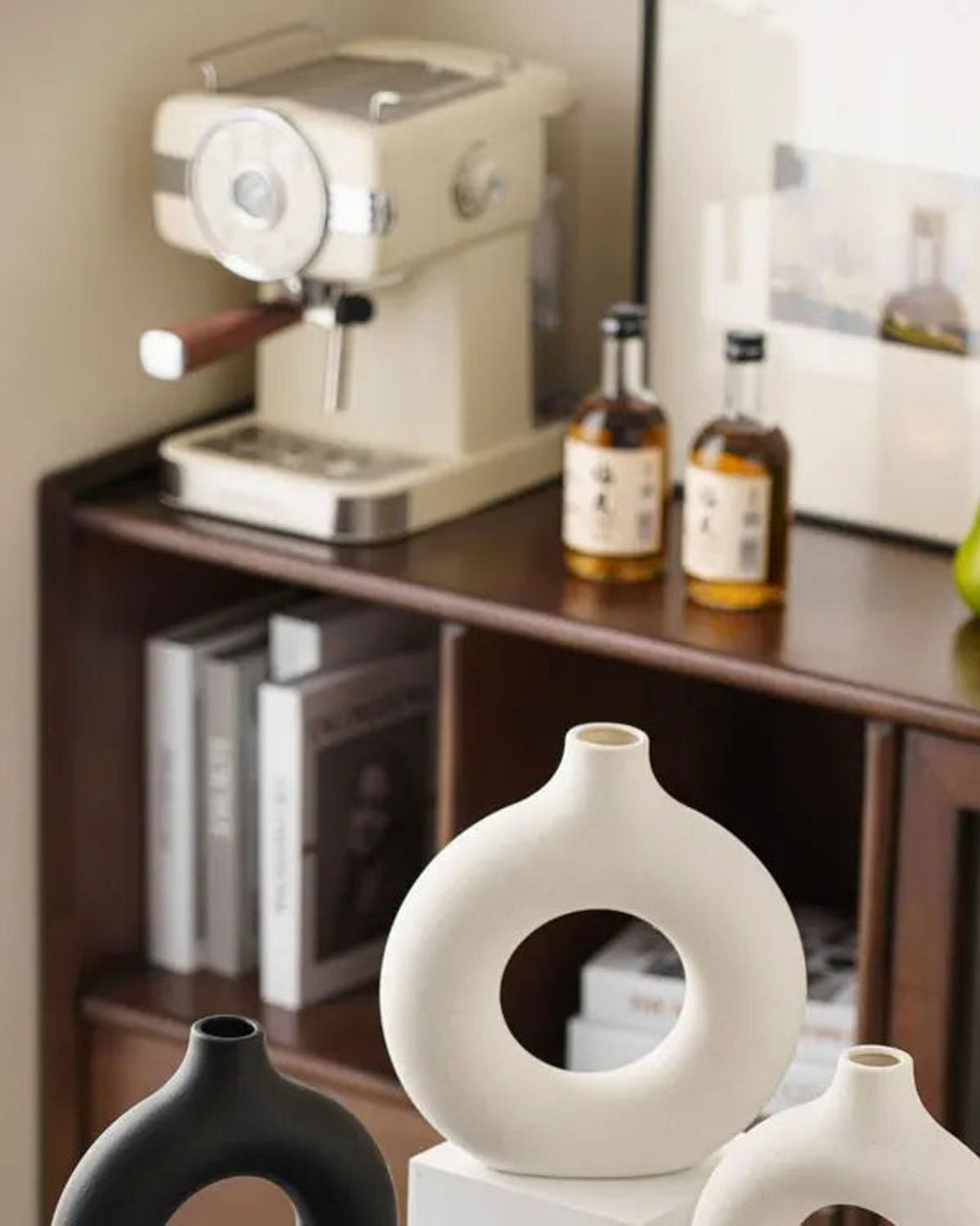 White donut vases on a kitchen sideboard beside a coffee machine; props not included