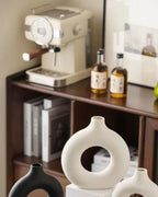 White donut vases on a kitchen sideboard beside a coffee machine; props not included