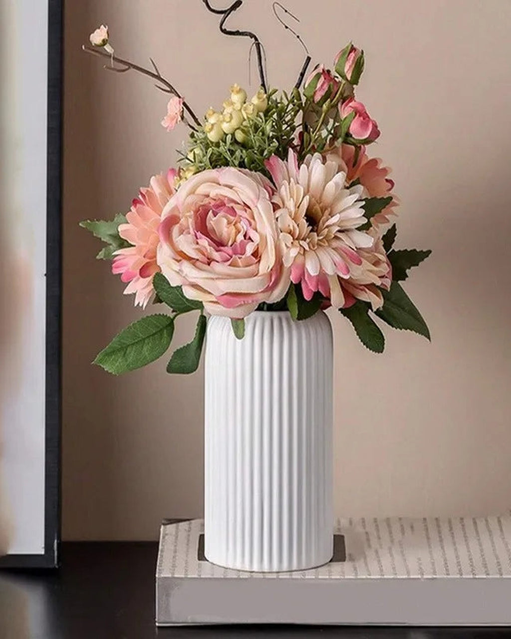 A white striped cylinder vase holding roses and dahlias; flowers not included
