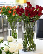 Roses standing in two clear acrylic cylinder vases on a table; flowers not included