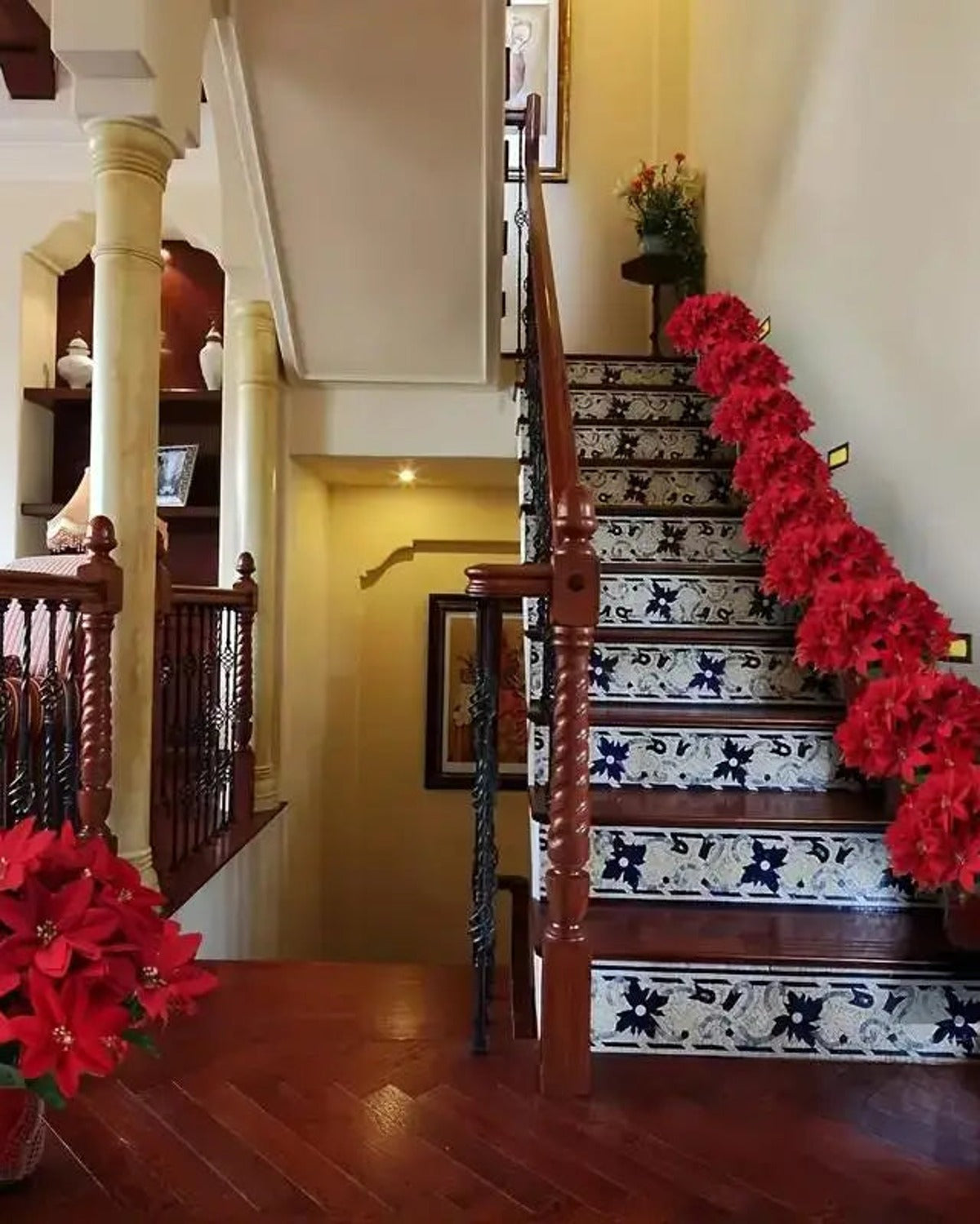Red poinsettia bouquets lining a staircase, one to a step; several bouquets shown