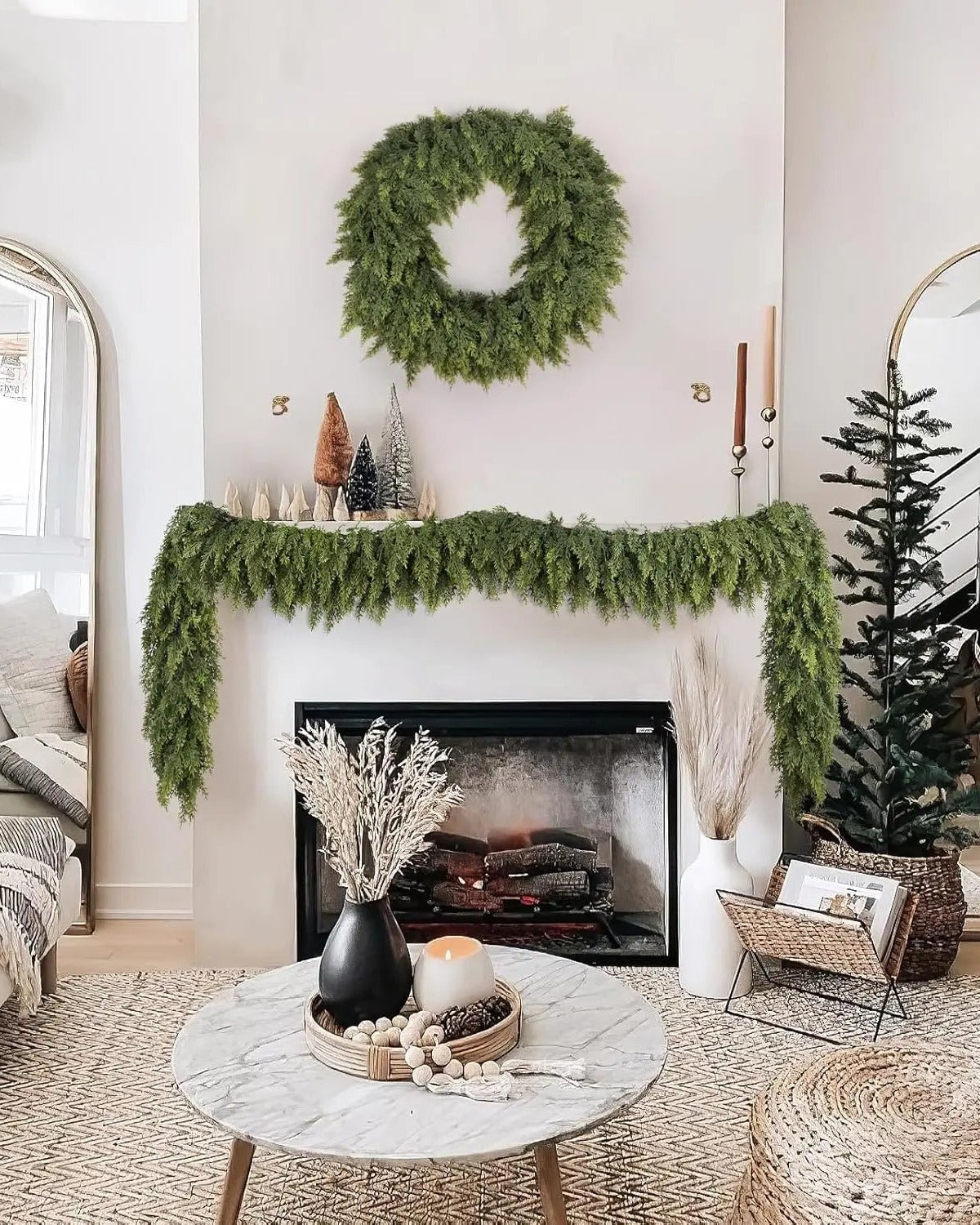 An artificial cypress garland along a white mantel under a matching wreath; wreath not included