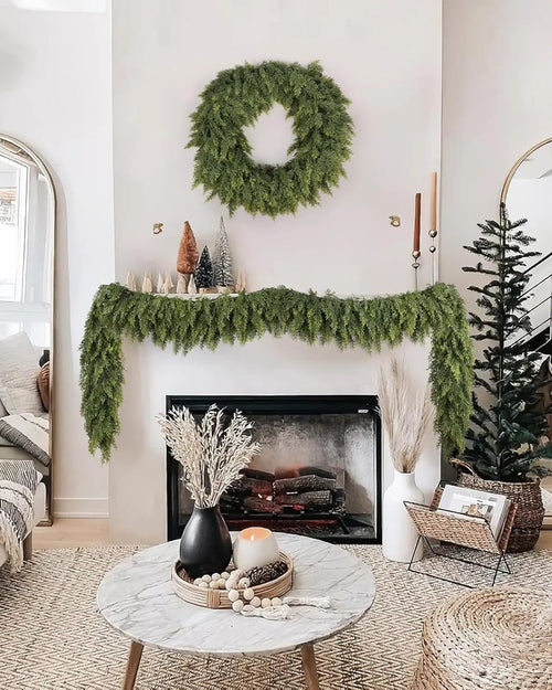 An artificial cypress garland along a white mantel under a matching wreath; wreath not included