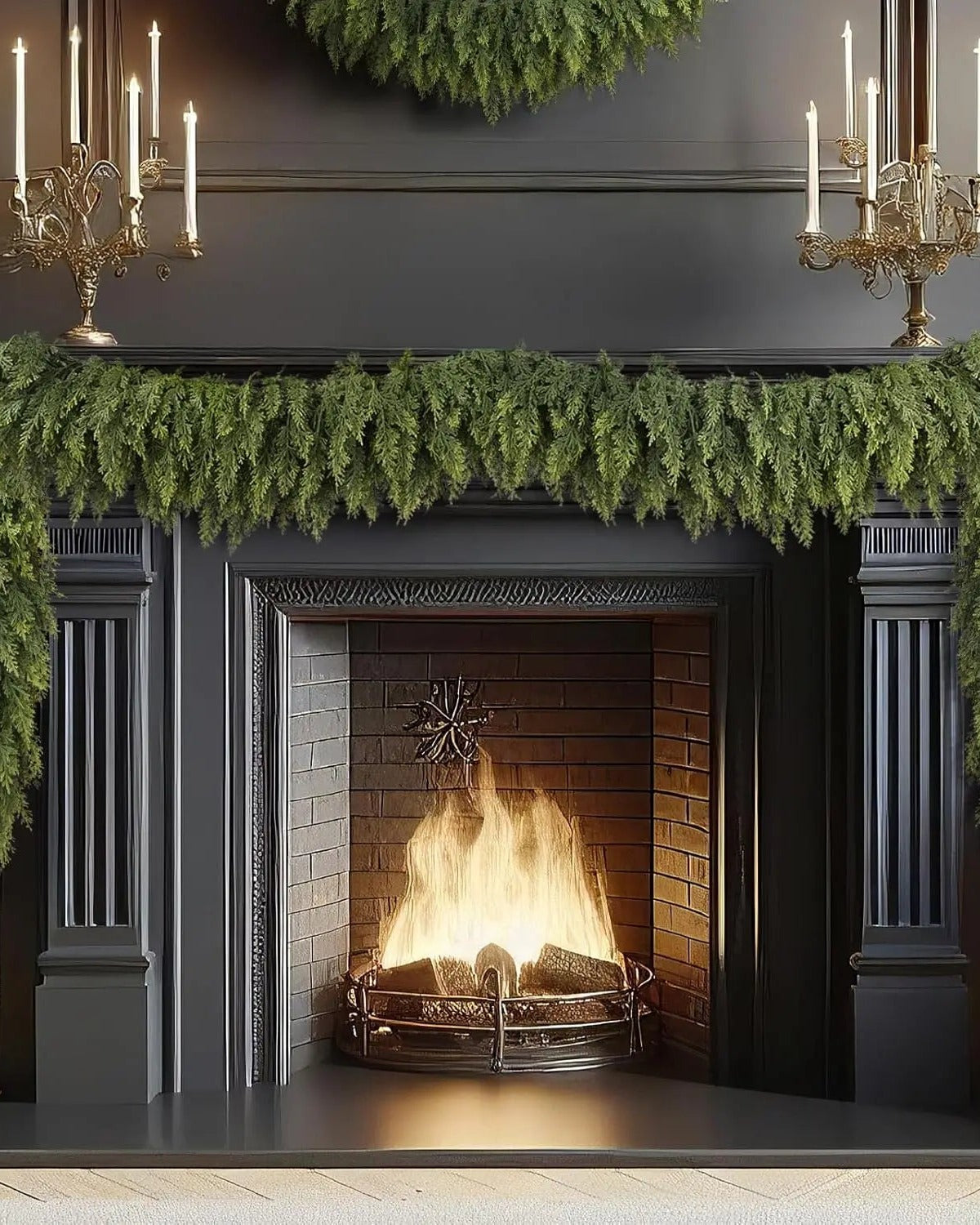 An artificial cypress garland draped along a black fireplace mantel