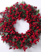 The berry and twig wreath on a plain white ground, red berries and long green leaves on a twig base