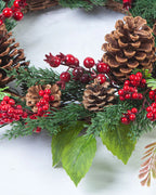 A close look at the cypress and pinecone wreath, pinecones, red berries and fern on a twig base