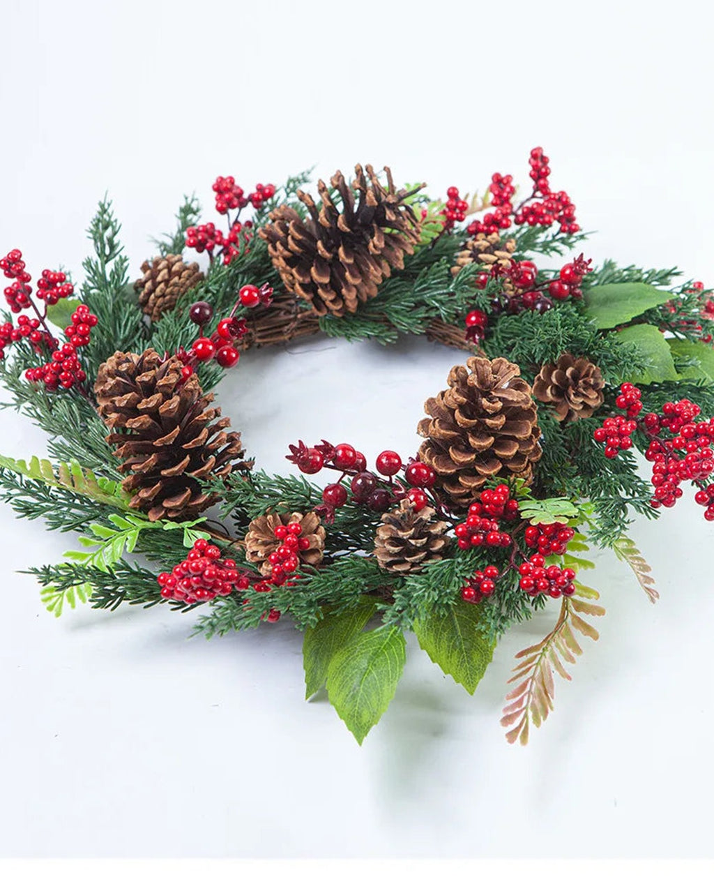 The cypress and pinecone wreath from a low angle on a white ground