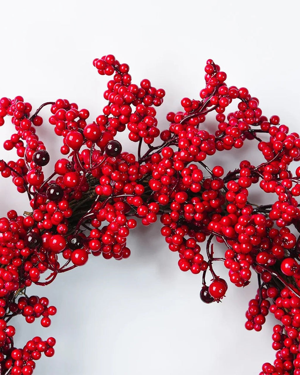 A close look at the red berry wreath's berry clusters