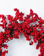 A close look at the red berry wreath's berry clusters