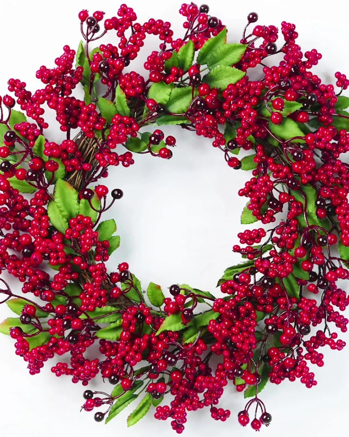 The berry and leaf wreath on a plain white ground, red berries and bright green leaves