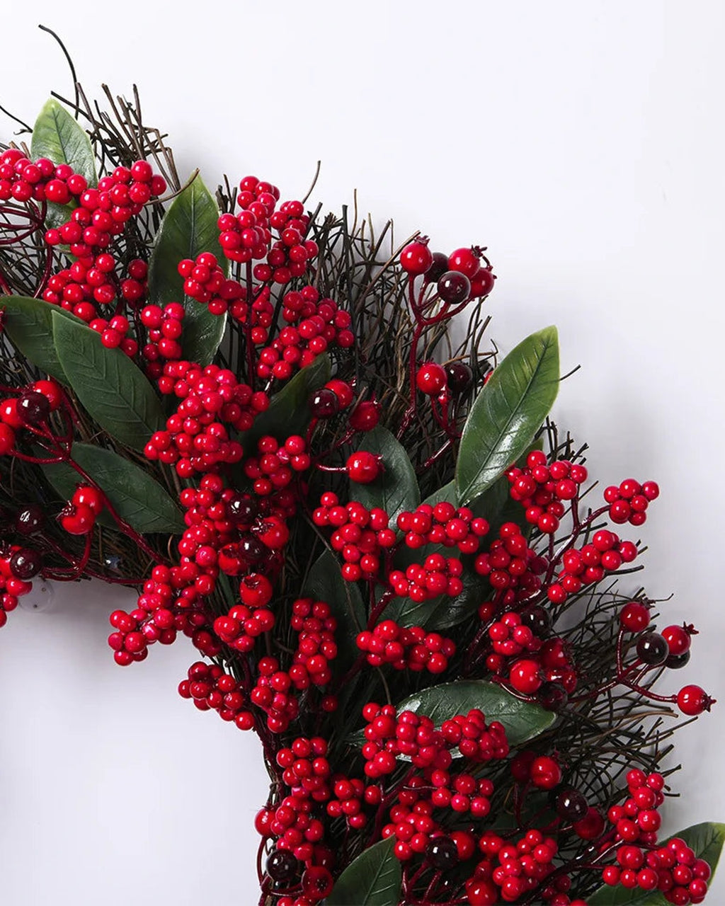 A close look at the berry and twig wreath, berries and long leaves over a twig base