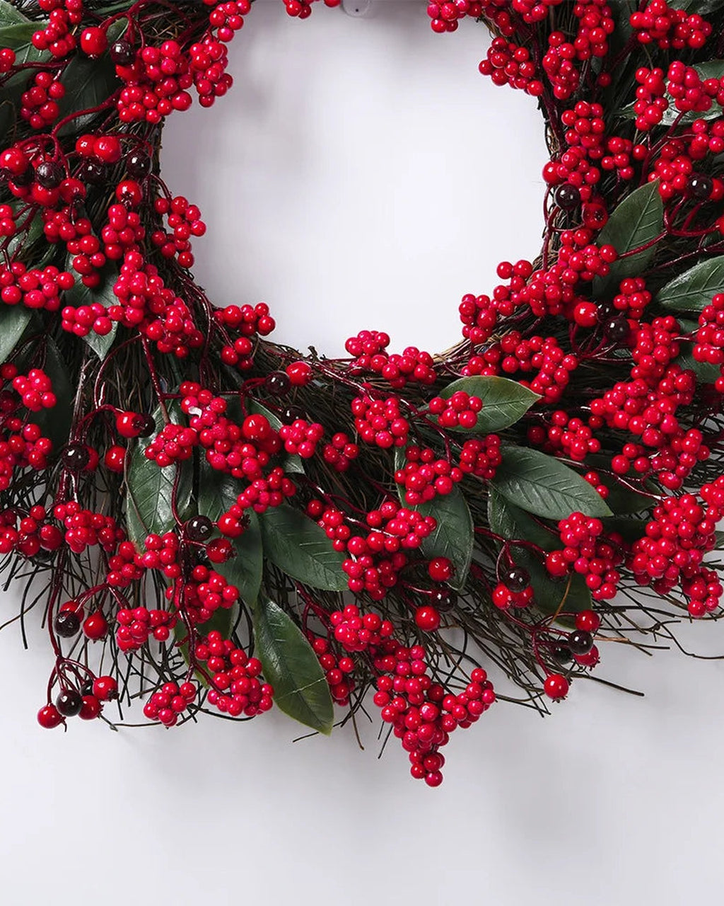 The lower half of the berry and twig wreath, dense red berry clusters over its twig base