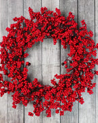 The red berry wreath on a gray wooden wall