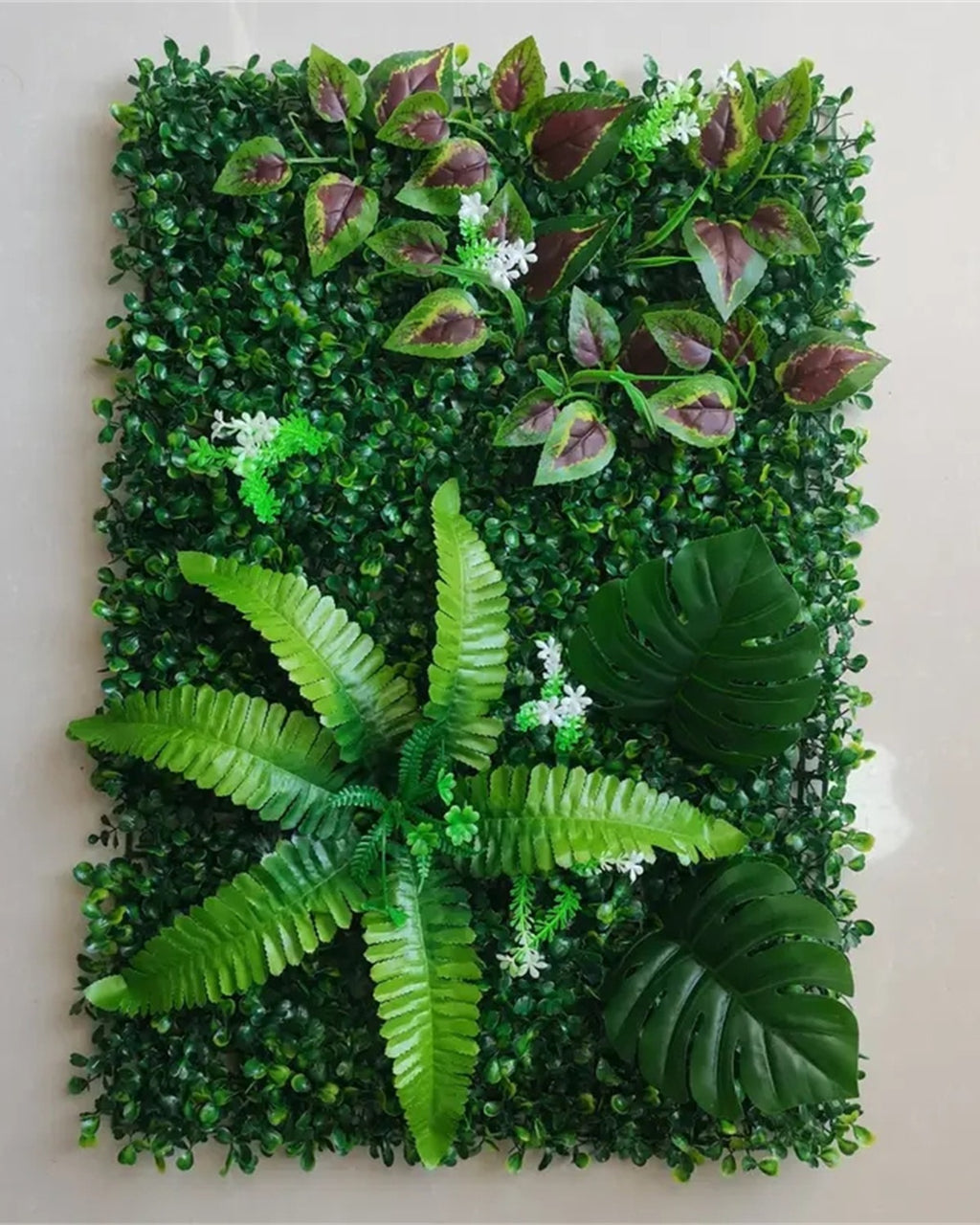 One panel seen flat, showing the ferns and broad leaves set into the boxwood