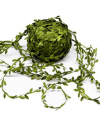 Coil of artificial leaf trim on a white background, one end unwound across the surface