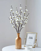 White plum blossom stems in a wooden vase beside a picture frame (vase not included)