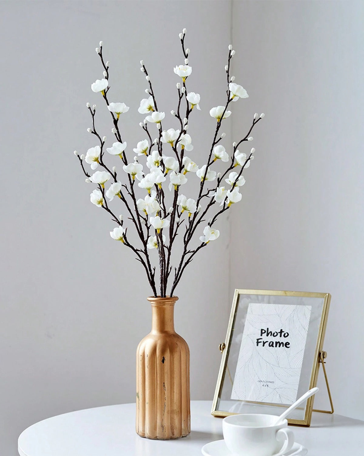 White plum blossom stems in a wooden vase beside a picture frame (vase not included)