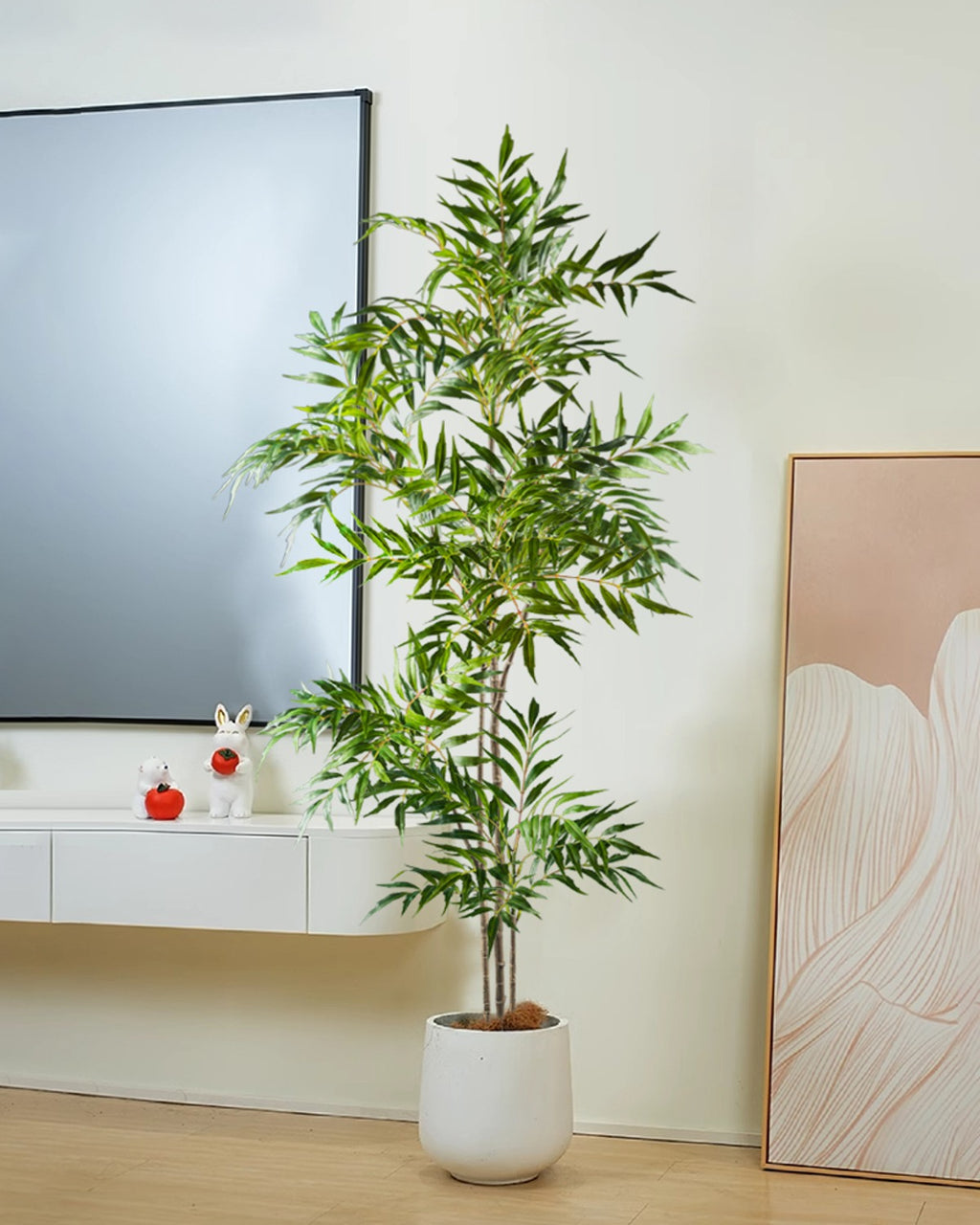 The bamboo branch in a white pot beside a low media unit and a leaning mirror (pot not included)