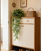 Artificial trailing vine on top of a hallway cabinet beside a woven basket