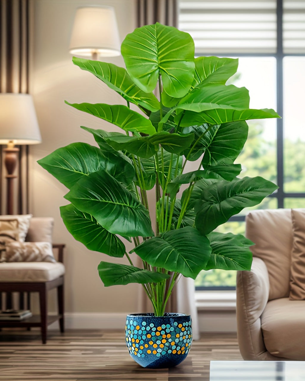 The elephant ear plant in a living room beside a lamp and an armchair (pot not included)