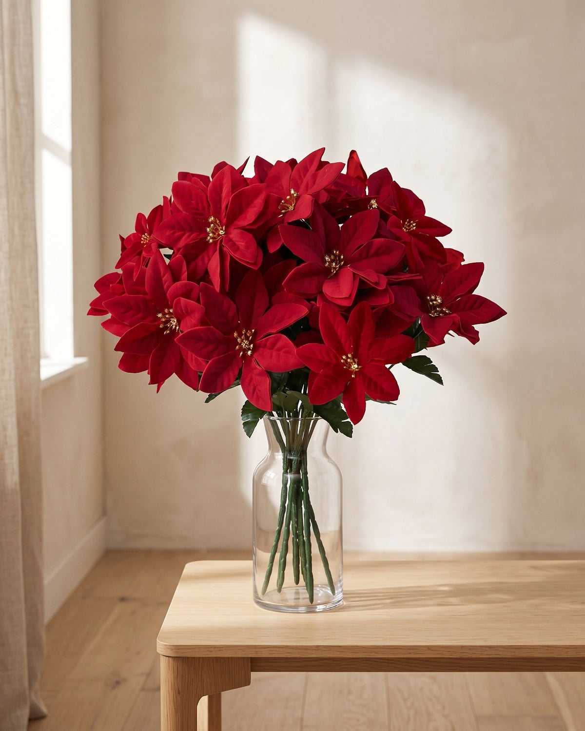 One red artificial poinsettia bouquet in a clear glass vase; vase not included