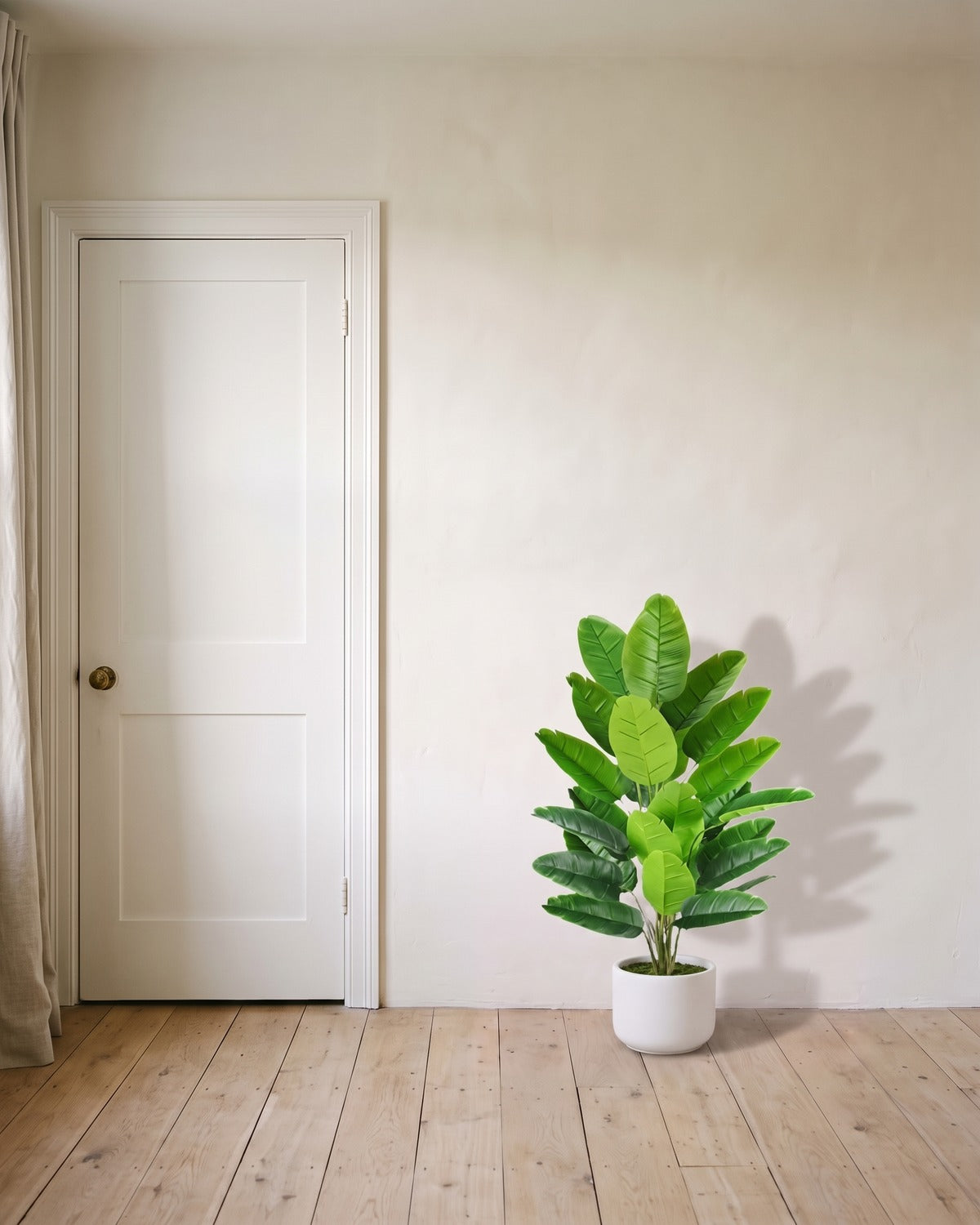 The 44 in artificial bird of paradise with twenty-four leaves, in a plain white pot beside an 80 in door to show its height; pot not included