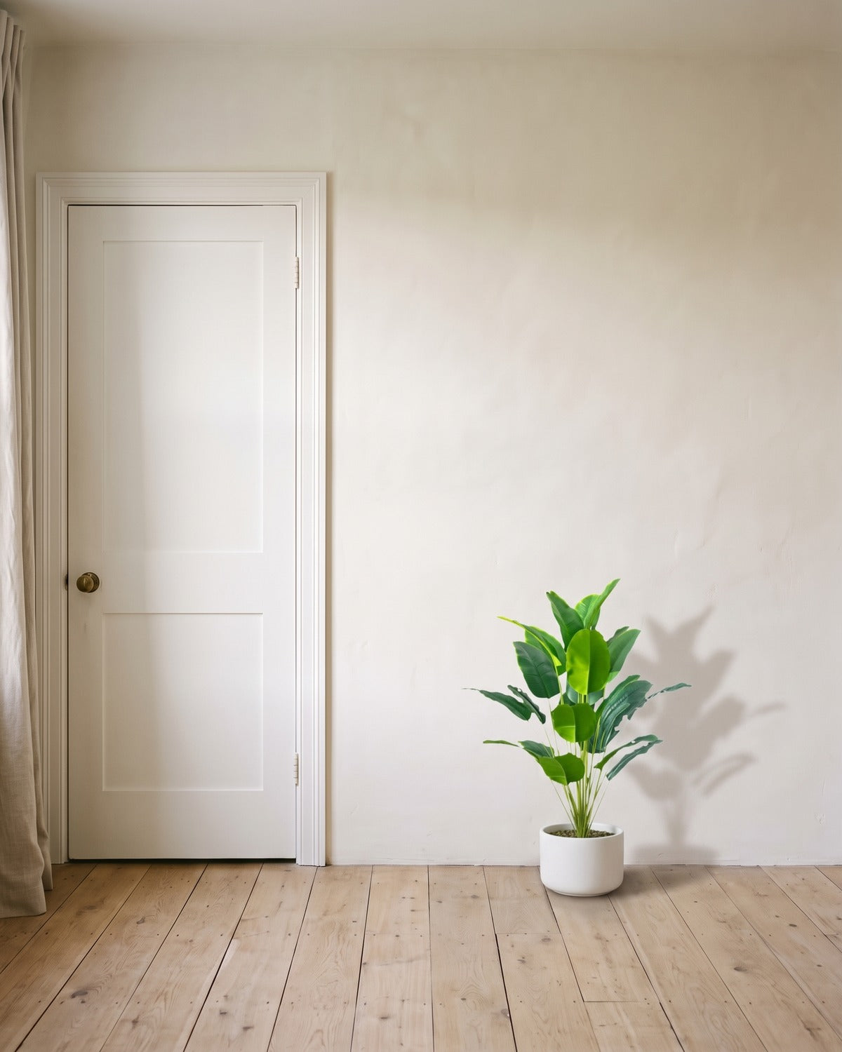 The 36 in artificial bird of paradise with twenty-four leaves, in a plain white pot beside an 80 in door to show its height; pot not included