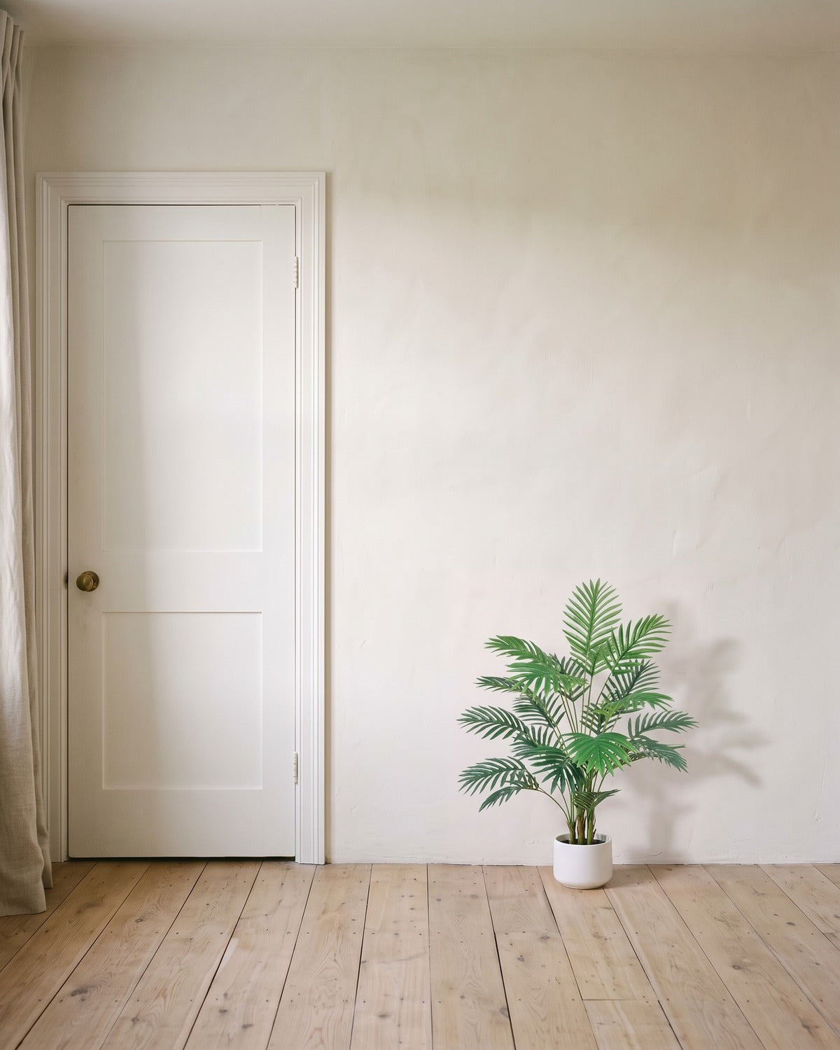 An artificial areca palm with twenty-four fronds, 35 in tall, in a plain white pot beside an 80 in door to show its height; pot not included