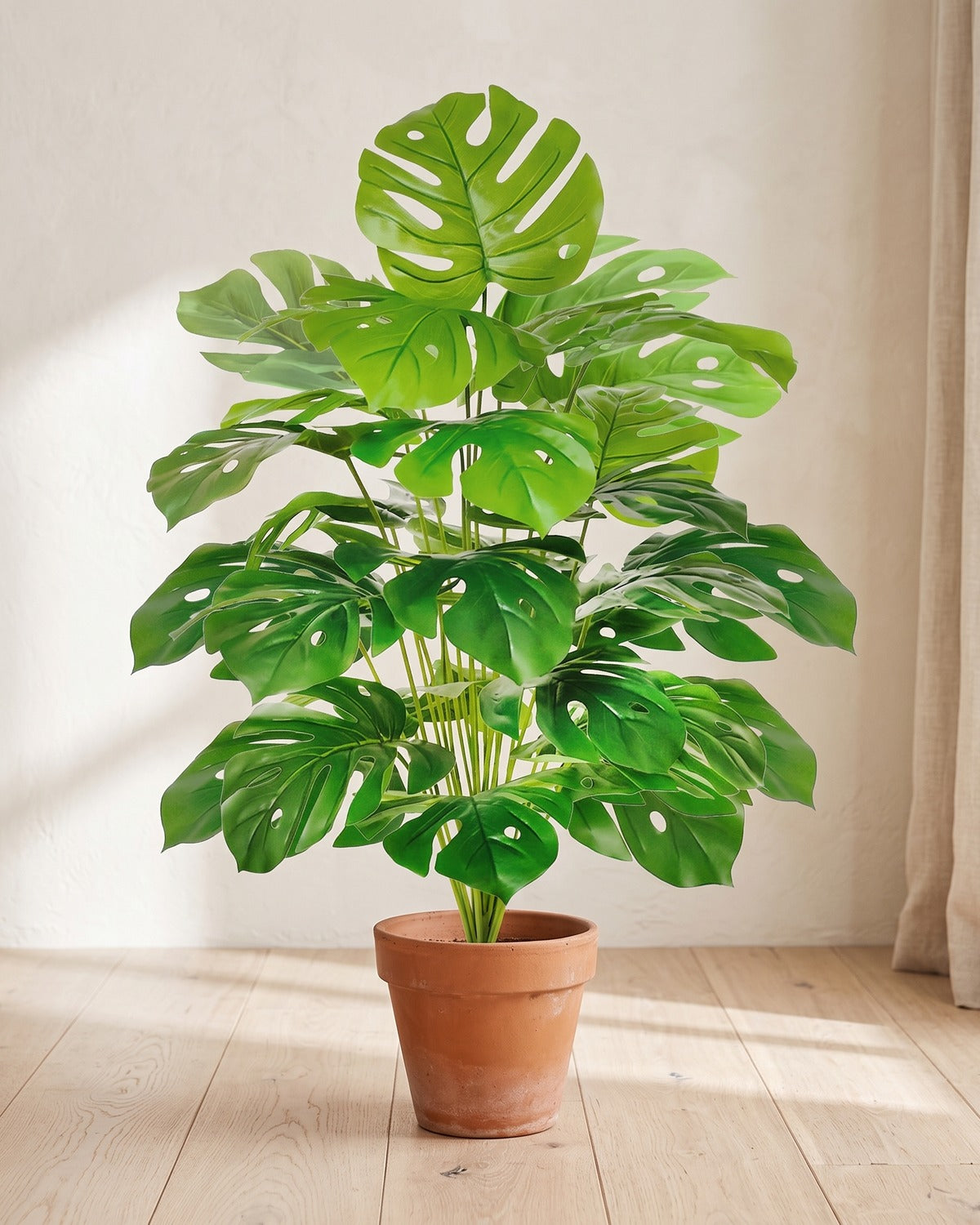 Pale green split leaf artificial leaf bush, 33.5 in with twenty-four leaves, in a plain terracotta pot on pale oak floorboards; pot not included