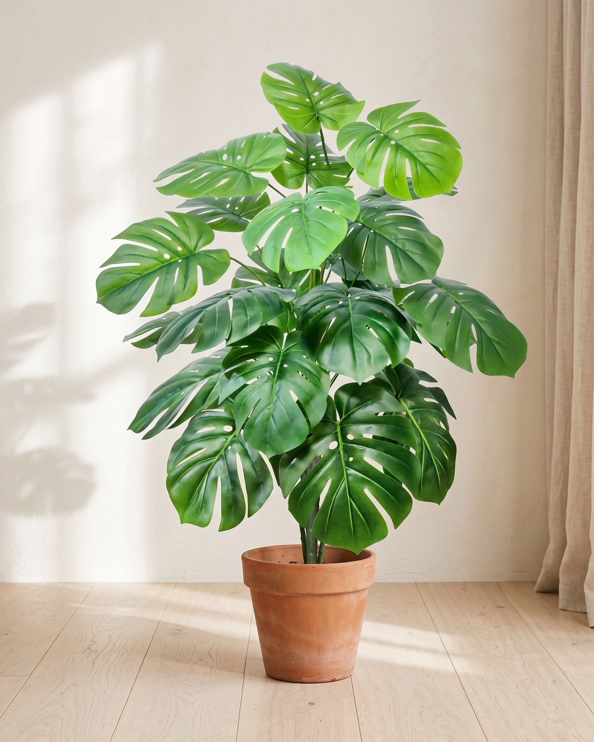 Deep green split leaf artificial leaf bush, 40.6 in with twenty-four leaves, in a plain terracotta pot on pale oak floorboards; pot not included