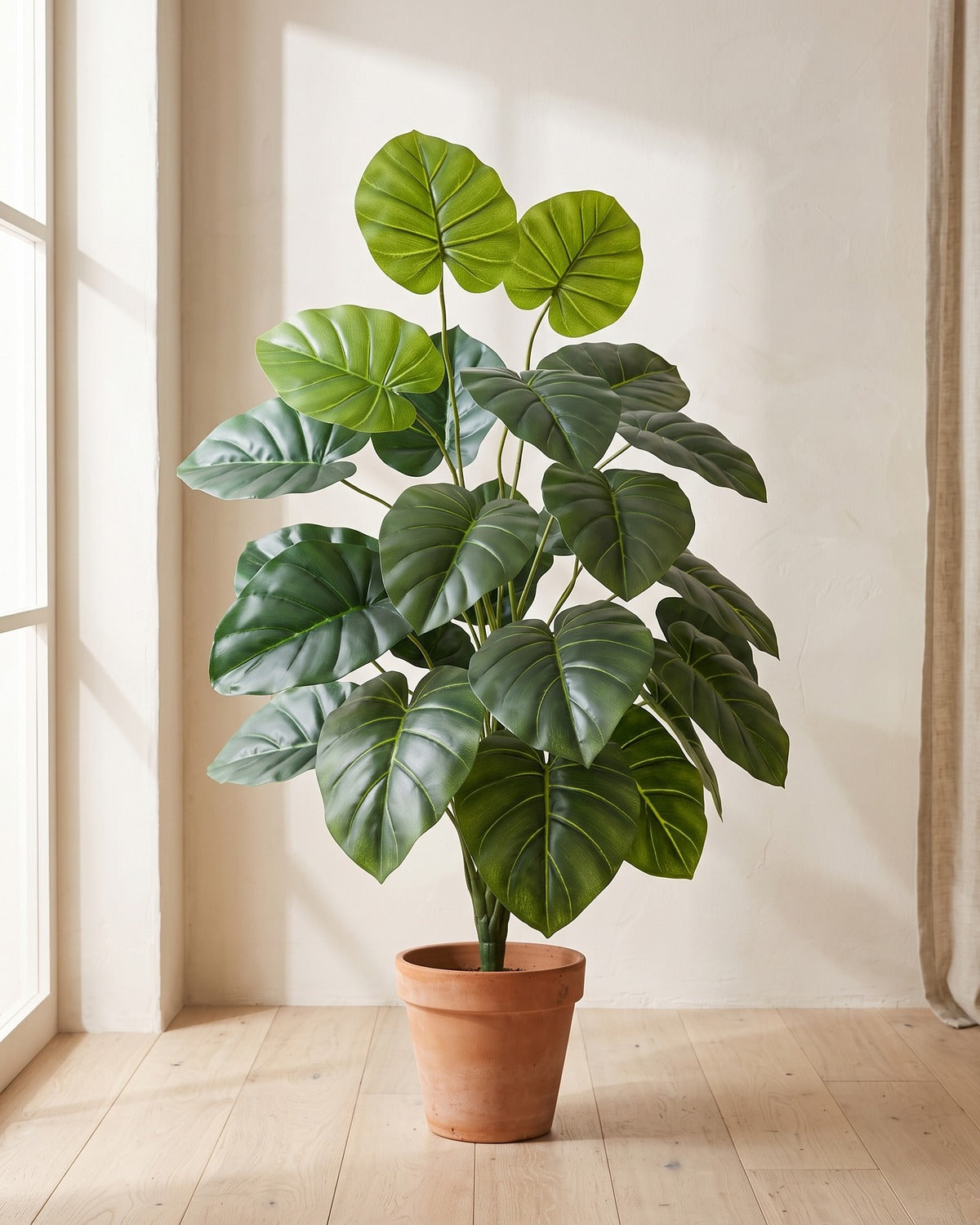 Deep green round leaf artificial leaf bush, 40.6 in with twenty-four leaves, in a plain terracotta pot on pale oak floorboards; pot not included