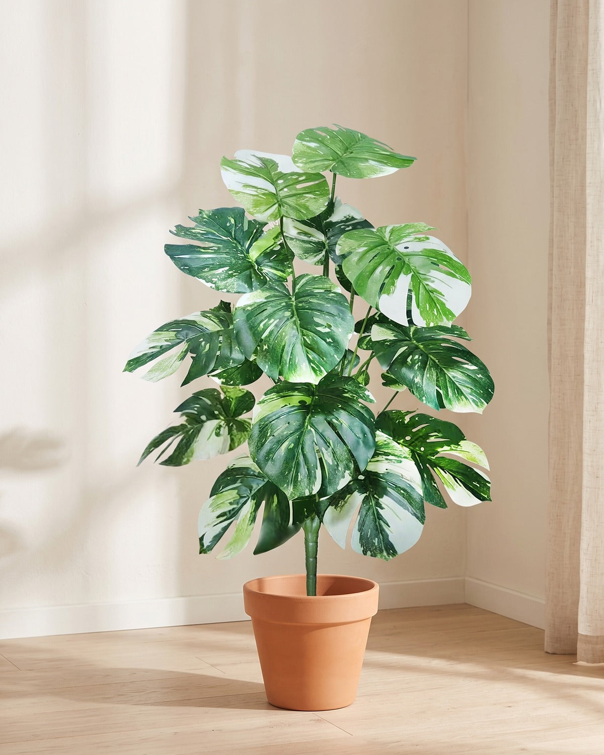 Variegated split leaf artificial leaf bush, 40.6 in with eighteen leaves, in a plain terracotta pot on pale oak floorboards; pot not included