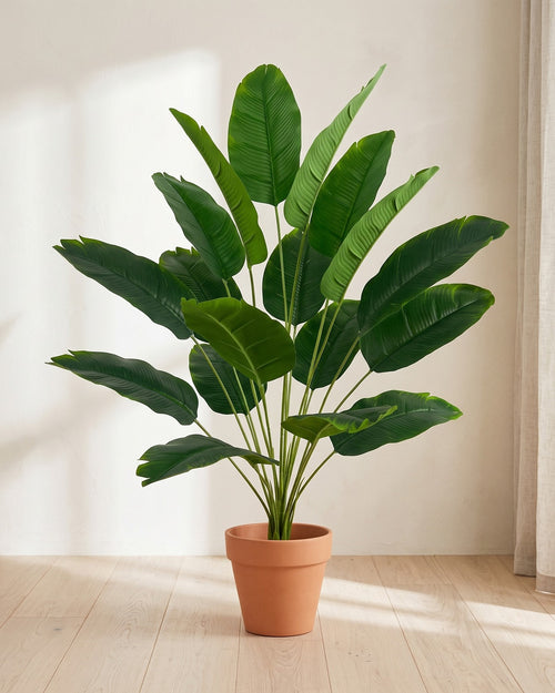 Artificial banana leaf bush, 32.3 in with eighteen leaves, in a plain terracotta pot on pale oak floorboards; pot not included