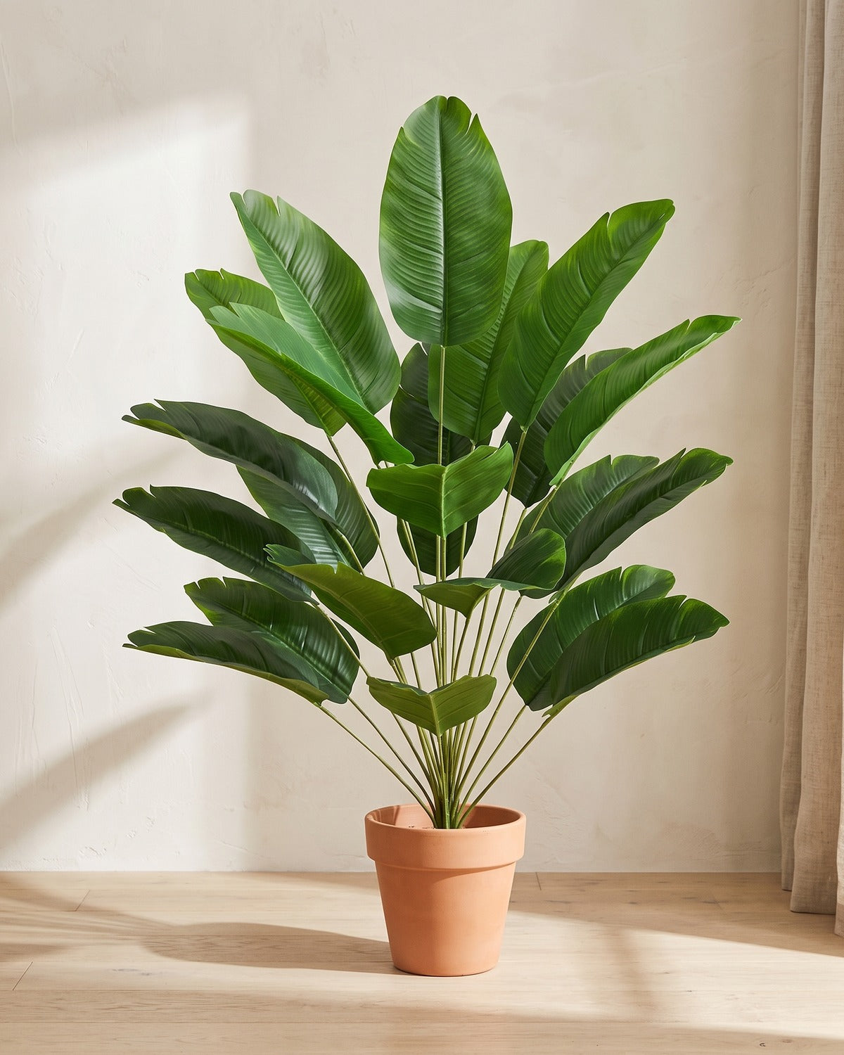 Artificial banana leaf bush, 35.4 in with twenty-four leaves, in a plain terracotta pot on pale oak floorboards; pot not included